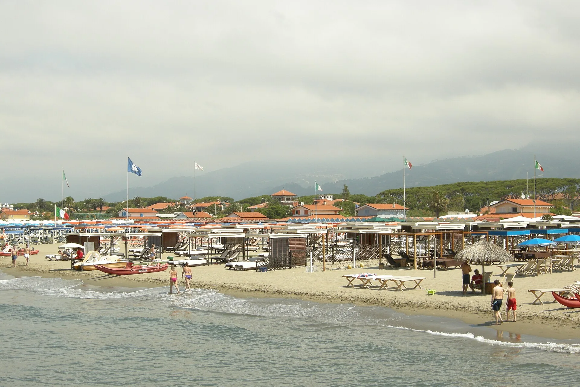 Spiaggia di Forte dei Marmi in estate, con ombrelloni, stabilimenti balneari e le Alpi Apuane sullo sfondo
